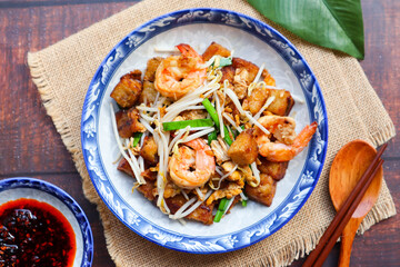 Stir fried turnip cake with shrimp, bean spout and chives with chili sauce on the side  - Chinese food called Char Koay Kak