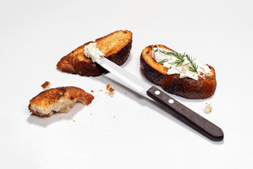 Cooking sandwiches. Slices of toasted bread and knife lie on white background.
