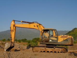 Obraz premium A yellow excavator works in a stone quarry.