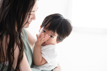 赤ちゃんを抱っこする笑顔の美人ママ ズーム コピースペースあり