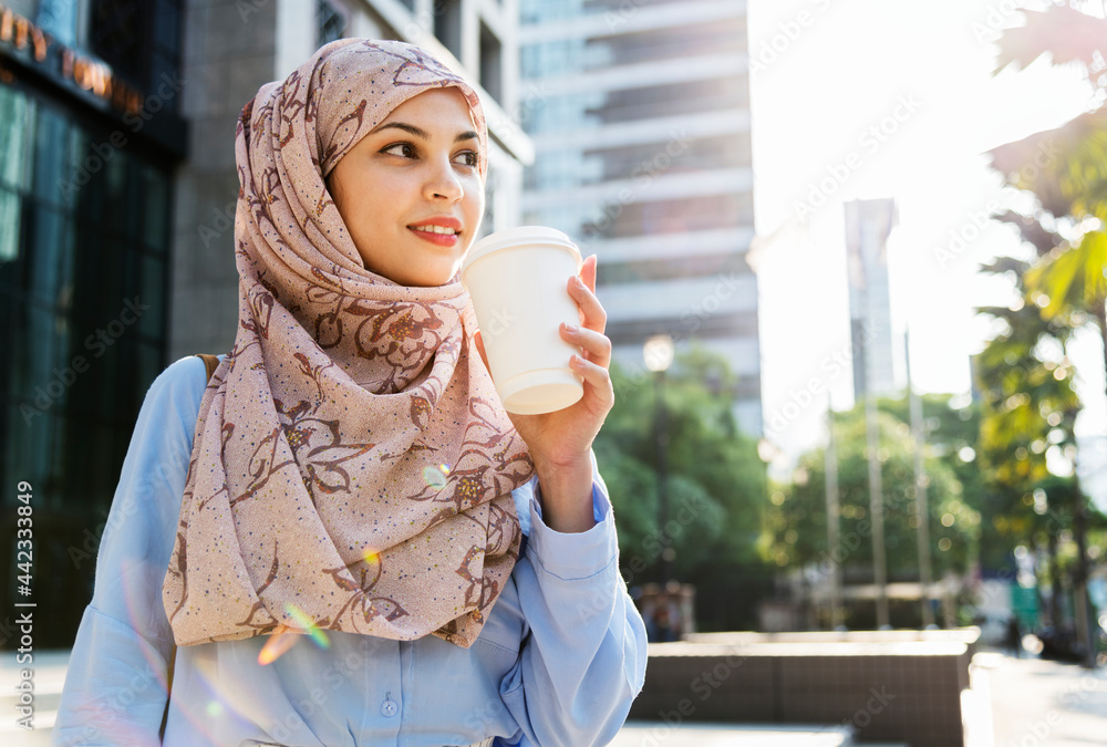 Sticker Muslim woman drinking coffee in the city