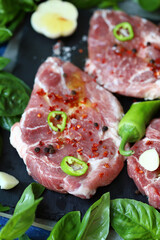 Fresh raw meat steak with spices and fresh basil.