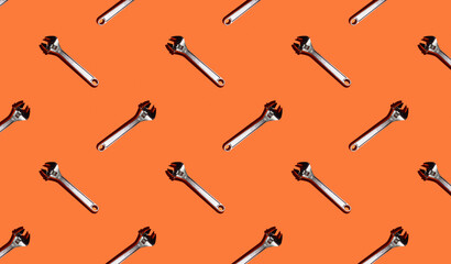Adjustable keys on an orange background, pattern, hard shadows. Construction tools, repairs. Background for the design.