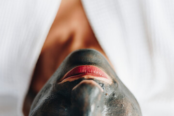 Woman relaxing with a charcoal facial mask
