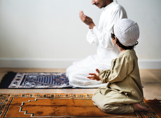                                                                   Little boy praying alongside his...