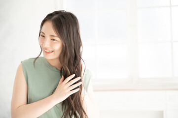 Fototapeta premium 髪の毛の調子をチェックする女性3 右にコピースペースあり