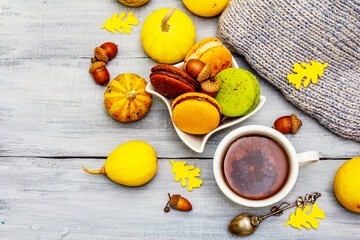 French macarons in autumn colors with cup of hot tea