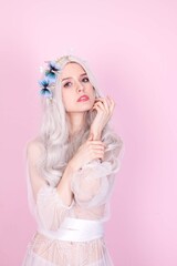 blonde girl in white clothes on a pink background