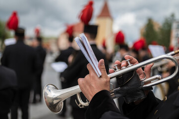 Detail of trumpet with man's hands in the background mining orchestra.