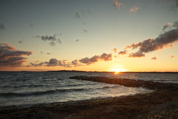 beautiful sunset over the rough sea with dark clouds