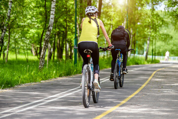 Fototapeta na wymiar Cyclists ride on the bike path in the city Park 