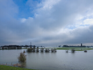Obraz premium Rivier De Lek gezien vanaf de Lekbandijk bij Ravenswaaij in de verte de schoorsteen van Steenfabriek de Bosscherwaarden