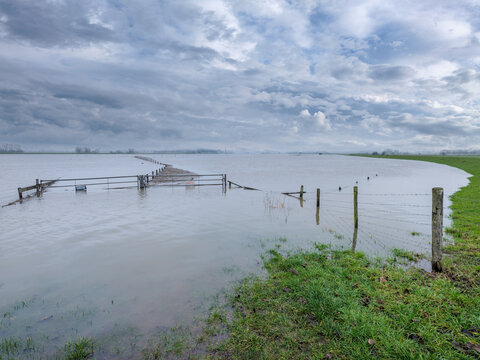 Hoogwater op de rivier De Lek gezien vanaf de Lekbandijk bij Ravenswaaij. Het bordje op het hek waarschuwt voor een gevaarlijke stier