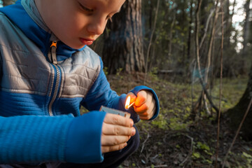 Child lighting match. The fire in the hands of a children. A little boy plays with flame. Danger of...