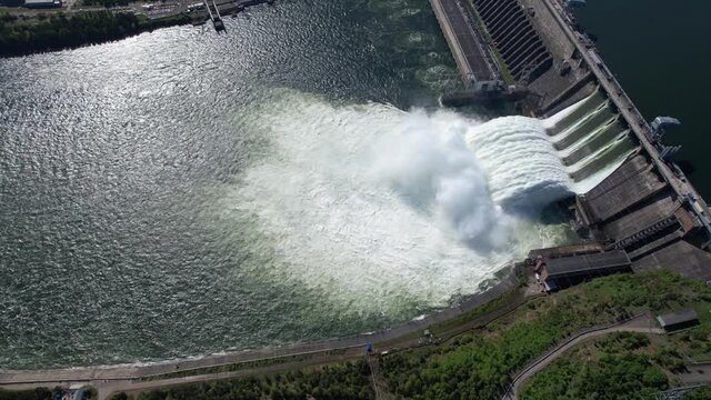 Hydroelectric dam on the river, water discharge from the reservoir, aerial footage, slow motion video