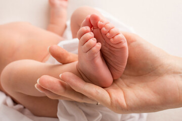 Fototapeta na wymiar hands of parents. the legs of the newborn in the hands of mom and dad. baby's legs in his hands. 