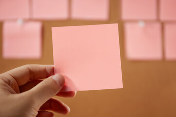 Obraz premium Hand holding a red empty sticky note