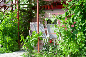 A table in an outdoor gazebo near the house. White table and chairs for lunch and dinner.