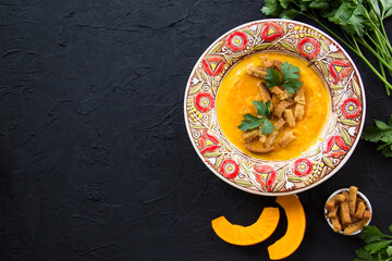 Delicious healthy pumpkin soup, herbs, and ingredients for the dish. Creative atmospheric decoration