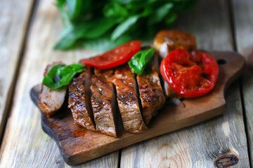 Appetizing juicy steak sliced on a wooden board.
