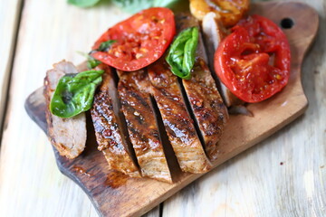 Appetizing juicy steak sliced on a wooden board.