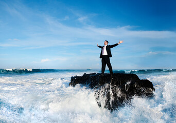 Businessman standing in a wavy sea