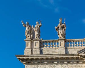 Obraz premium Statues on the roof of the Papal Archbasilica of St. John in Lateran (Basilica di San Giovanni in Laterano) in a sunny day, Italy, Rome