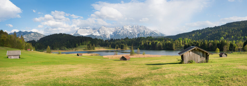 alpine meadow with wooden huts, view to Karwendel mountains, panorama bavaria