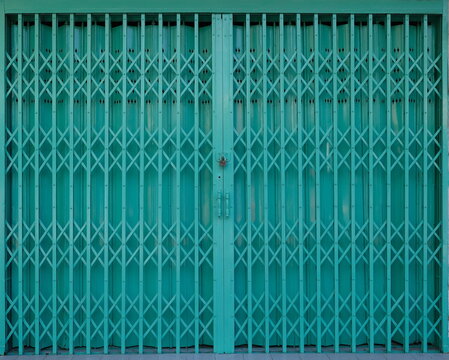 Folding metallic grille in front of a shop