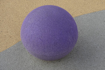 Close up of a lilac color ball on yellow and gray textured background. Reidi street, Tallinn, Estonia
