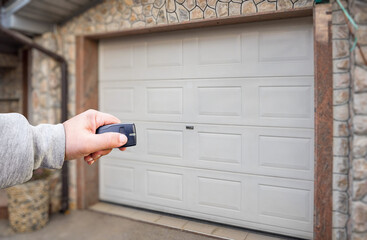 Garage door PVC. Hand use remote controller for closing and opening garage door
