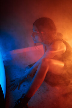 Woman sitting near old television in darkness