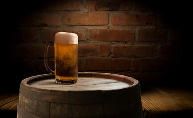 Beer barrel with beer glass on table on wooden background