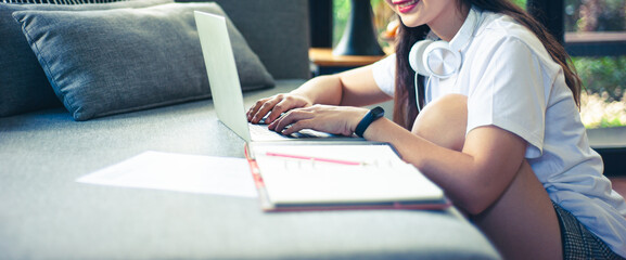 Girl working from home with laptop in living room at home.