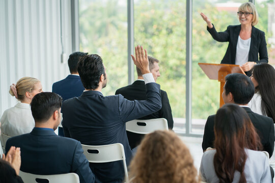 A Woman Leader Giving A Talk In Business Event. Group Of Business People Workshop Training At Seminar Room. Businessman Raising Hands To Asking Question