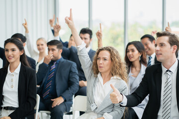 group of business people workshop training in business event at seminar room. business people rasing hands up