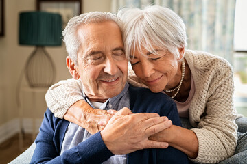 Loving senior couple hugging at home