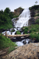 famous pisciai waterfall in the mountains of Piedmont, italy, on the path to refuge migliorero, with grass, stones and a wooden brigde - 442356063