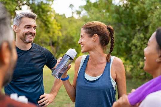 Thirsty mature woman drinking water after workout