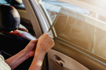 The worker is removing the car mirror old film stain by hand