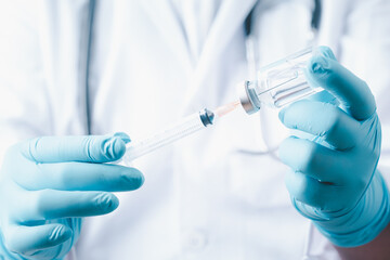 Doctor holding  syringe with  single bottle vial of vaccine for children or adults. Concept fight...