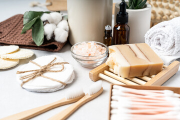 Fototapeta na wymiar Natural bathroom and home spa tools. Zero waste sustainable lifestyle concept. Bamboo toothbrush, natural soap bar, cotton pads, homemade DIY beauty products in reusable bottles on white background.