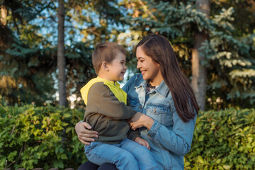 portrait of a happy young mother with a young son in the park. the concept of happy motherhood