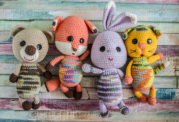 Crocheted teddy bear hare cat and chanterelle on a wooden background.