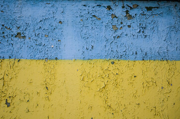 Vintage wooden background with faded turquoise and yellow peeling paint.
