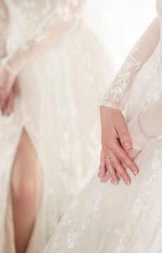 Silhouette of the bride in a white lace dress and a hand with a ring. Reflection in the mirror. gentle photo.