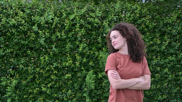 Woman with curly hair and crossed arms.