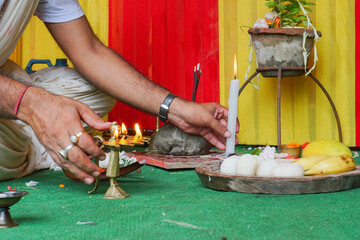 Hindu priest lighting up holy fire or holy light for worshipping idol of God Jagannath, Balaram and Suvodra. Ratha jatra festival is famous Hindu festival in India. Howrah, West Bengal, India.