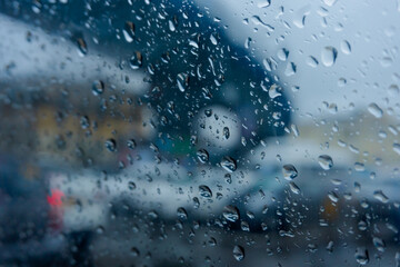 Image shot through raindrops falling on wet glass, abstract blurs of traffic - monsoon stock image of Kolkata (formerly Calcutta) city ,