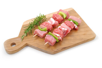 Spiedini di carne di maiale crudi su tagliere in legno isolato su sfondo bianco